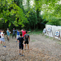 Participants au tir à l'arc face à des cibles, en sous-bois