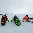 Trois motoneiges dans la neige