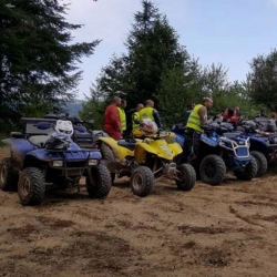 Quads alignés et participants en gilet jaune en lisière de forêt