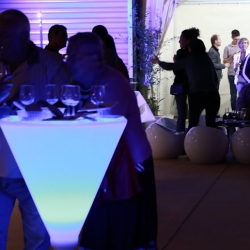 Mange-debout lumineux et invités pendant une soirée