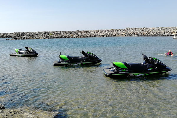 Trois jet-skis sur l'eau, près d'une digue